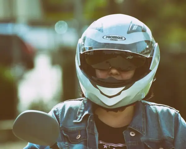 Persona con casco jet, non un demi-jet, pronta per un giro in moto. La differenza è nella copertura.