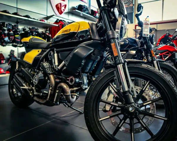 Una moto gialla e nera, con altre moto in esposizione. Diversi tipi di moto pronti per essere scelti.
