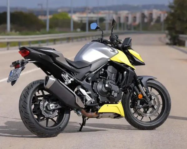 Honda CB 750 Hornet grigia e gialla parcheggiata su strada.