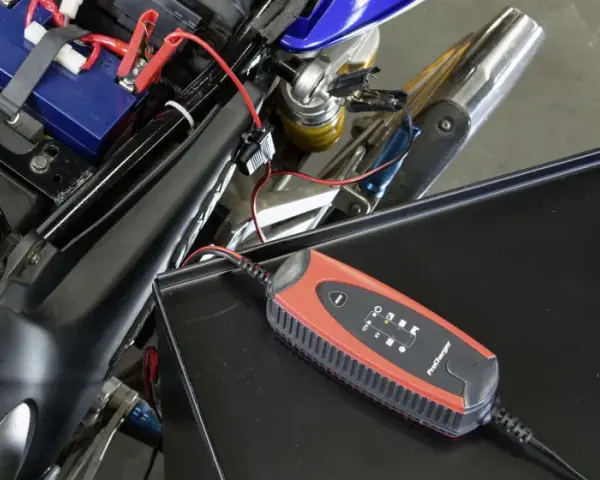 Caricabatterie collegato alla batteria di una moto. Un modo semplice per **come ricaricare le batterie** e ripartire.