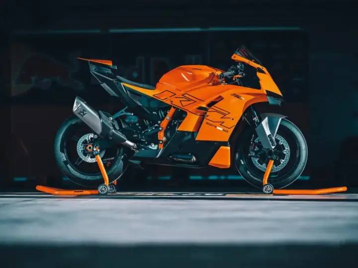 La KTM 890 Duke GP, arancione e nera, pronta per la pista, con scarico Akrapovič e cavalletti arancioni.
