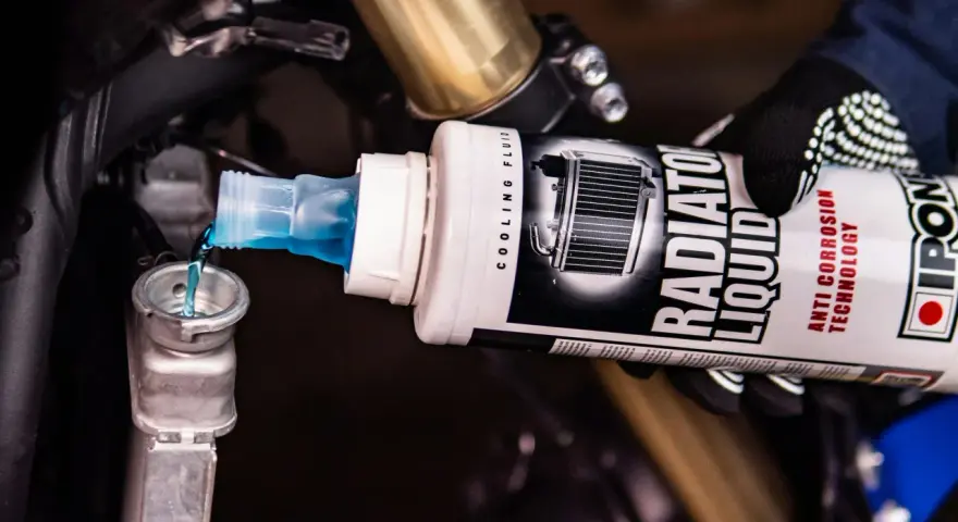 Versando liquido radiatore moto, uguale a quello per auto, nel serbatoio di raffreddamento.