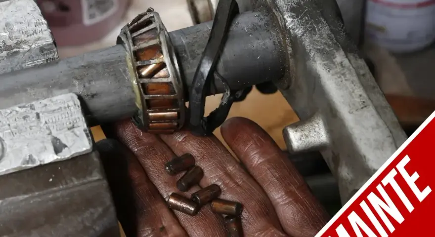 Manutenzione albero motore T-Max: cuscinetto usurato e rullini sparsi nella mano.
