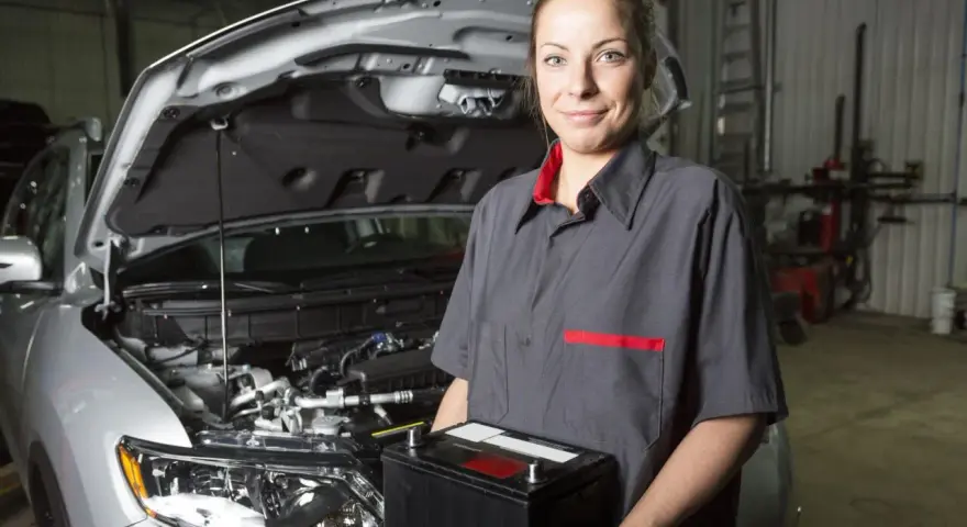 Meccanica sorridente con una nuova batteria, pronta per mostrare come montare una batteria auto.