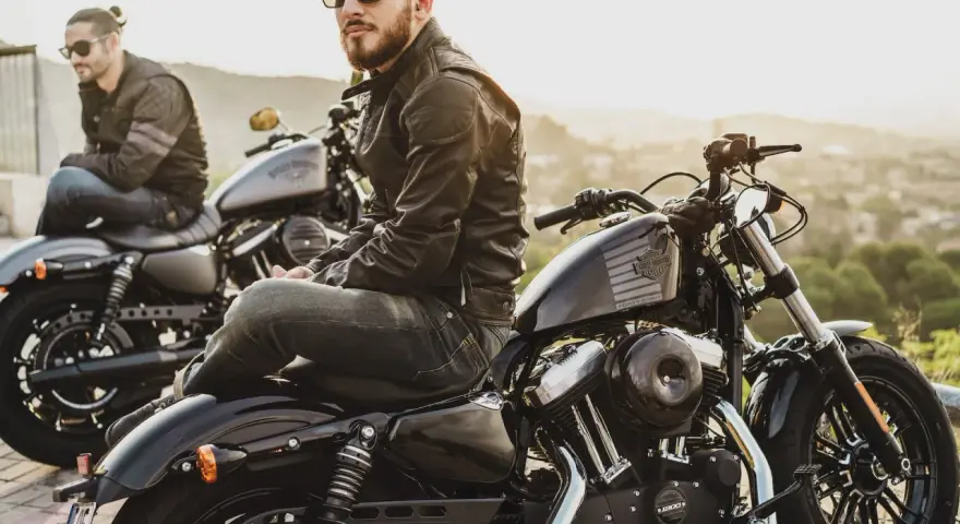 Due motociclisti con giacche di pelle e jeans, pronti per un viaggio. L'abbigliamento del motociclista è essenziale per la sicurezza e lo stile.