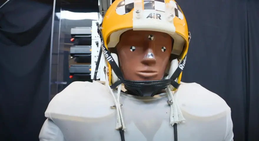 Manichino con casco giallo e bianco, con segni di misurazione, pronto per testare come capire se un casco è omologato.