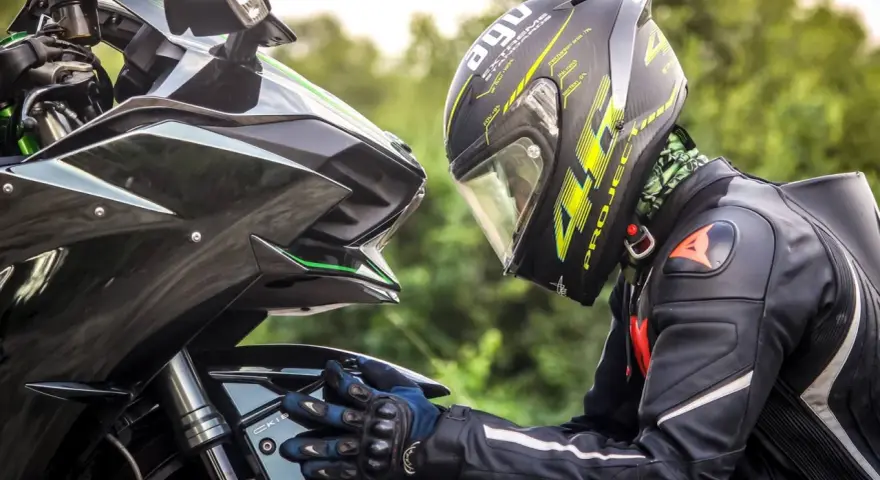 Motociclista con casco AGV e tuta Dainese, dettagli sul materiale caschi moto e la sua aerodinamica.