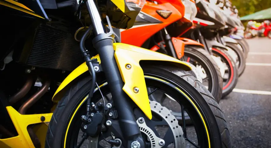 Una fila di moto sportive, tra cui una Yamaha scarenata gialla in primo piano, pronte per la corsa.