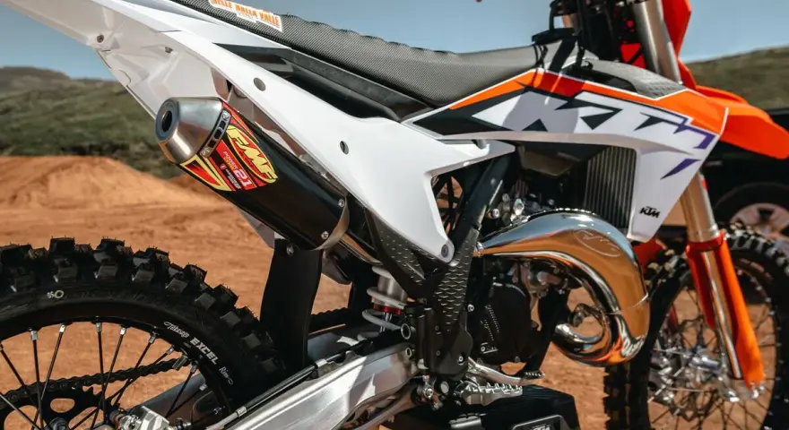 Dettaglio di una moto da cross KTM con scarico FMF. Il suo motore 4 tempi è pronto per la pista.