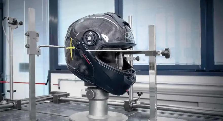 Casco in carbonio in fase di test, con strumenti di misurazione. Verifica della scadenza omologazione casco E3 per garantire la sicurezza.
