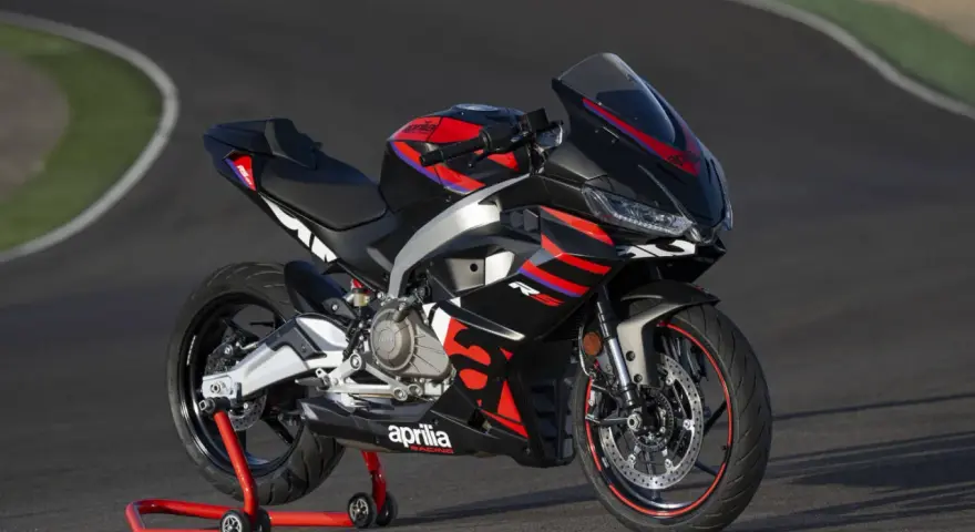 Aprilia RS 457, una moto sportiva nera con grafiche rosse e blu, pronta a sfrecciare su un circuito.