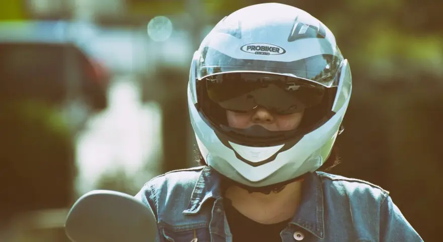 Persona con casco jet, non un demi-jet, pronta per un giro in moto. La differenza è nella copertura.