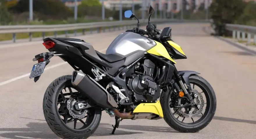 Honda CB 750 Hornet grigia e gialla parcheggiata su strada.