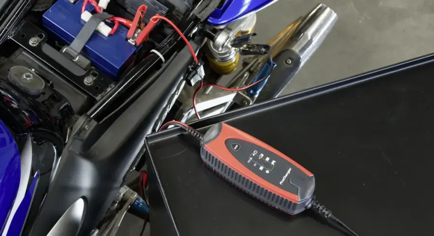 Caricabatterie collegato alla batteria di una moto. Un modo semplice per **come ricaricare le batterie** e ripartire.