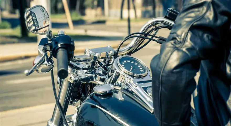 Man in leather jacket on motorcycle, dashboard shows alta temperatura eccessiva liquido radiatore.