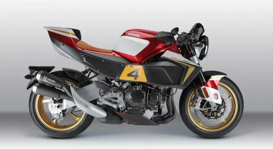 La Bimota KB4, una moto sportiva con serbatoio rosso e bianco, sella marrone e dettagli dorati.
