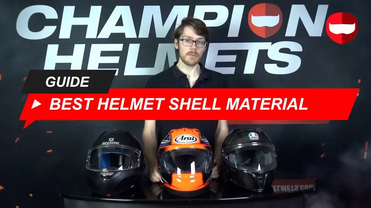 Tre caschi da moto di marche diverse (Shark, Arai, AGV) sono esposti. Sopra, un uomo presenta una guida sui materiali della calotta esterna del casco.