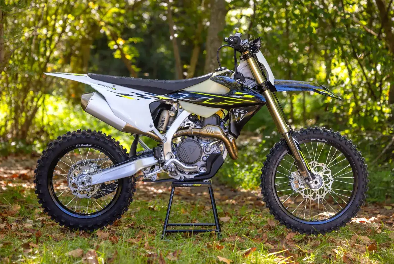 Moto da cross Triumph, con livrea bianca, nera e gialla, pronta per avventure off-road.