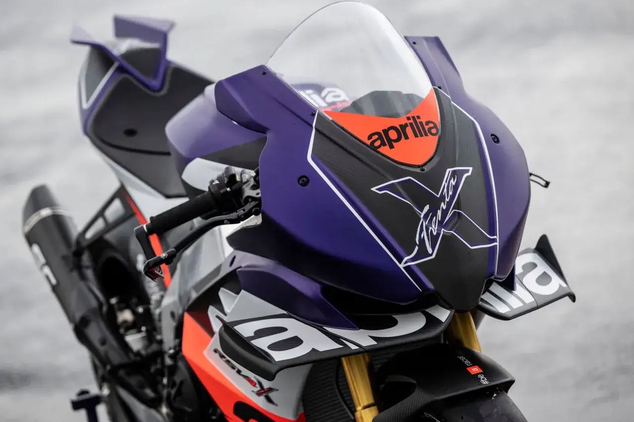 Aprilia RSV4 Xtrenta, una moto da corsa con carenatura viola e carbonio, pronta a dominare la pista.