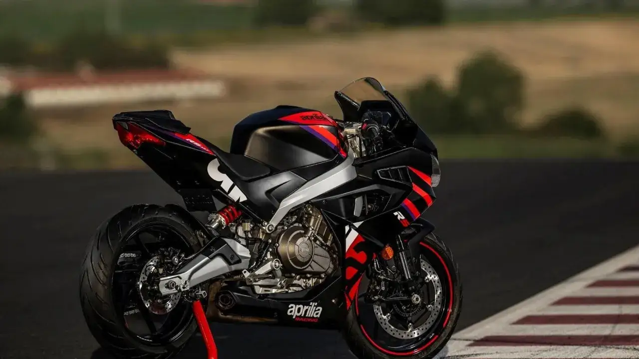 Aprilia RS 457 nera con grafiche rosse e viola, pronta per la pista.