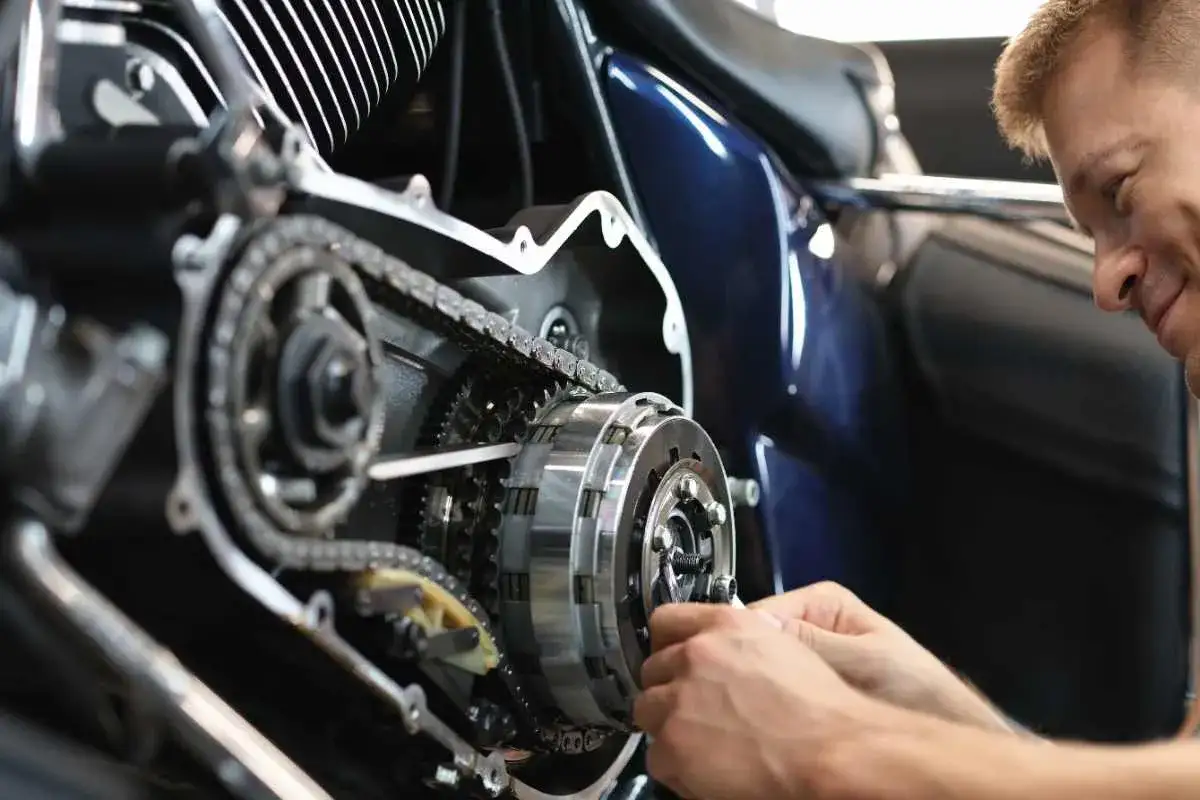 Meccanico lavora su frizione di moto d'epoca rare. Dettagli del motore e della catena.