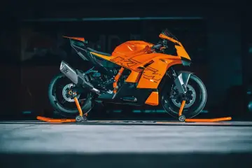 La KTM 890 Duke GP, arancione e nera, pronta per la pista, con scarico Akrapovič e cavalletti arancioni.